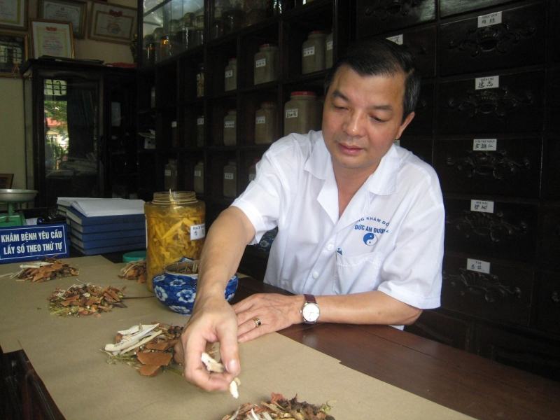 Healer Pho Huu Duc is cutting medicine for his patient