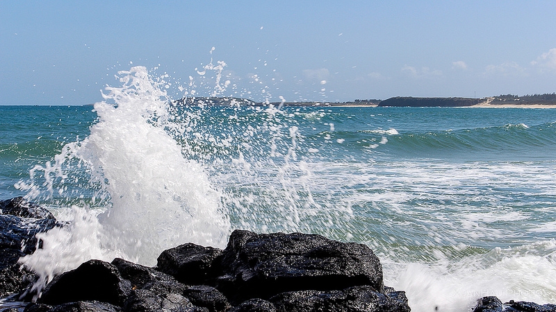 The waves lapped the shore, splashing white foam.