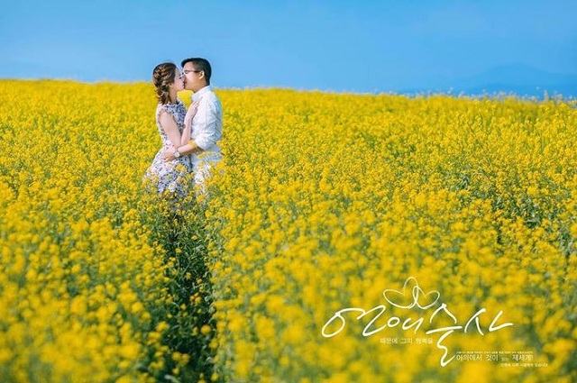 Photo of romantic lovers in the field of yellow canola flowers in Dalat