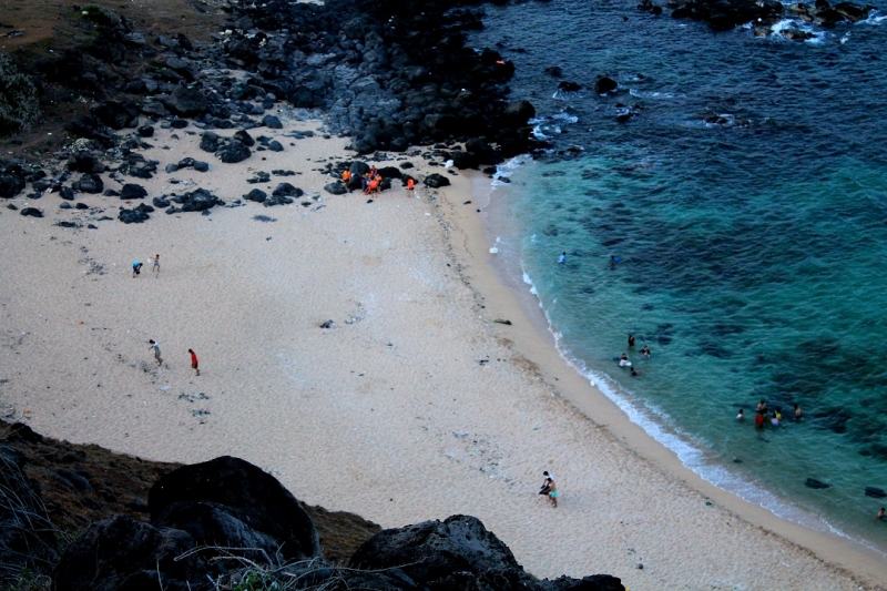 The crescent-shaped sandy beach is bounded by rocky headlands that jut out into the sea.