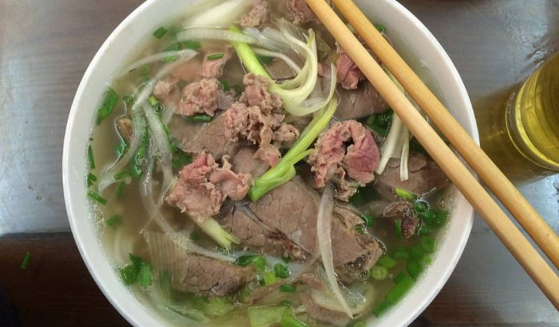 A full bowl of pho lots of meat, delicious square noodle soup, seasoned broth to taste